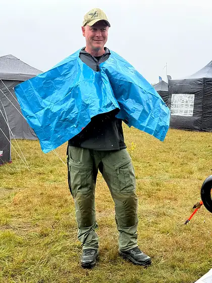 Teilnehmer mit DDoptics-Kappe und blauem Regenschutz im Wettkampfcamp