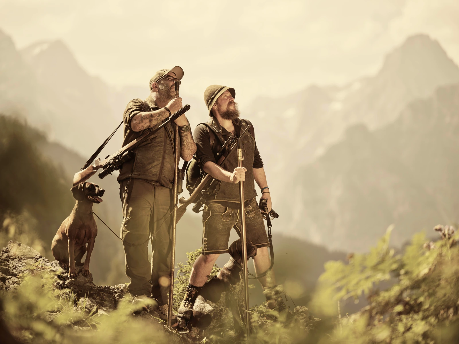 Two hunters and a dog in a mountain landscape