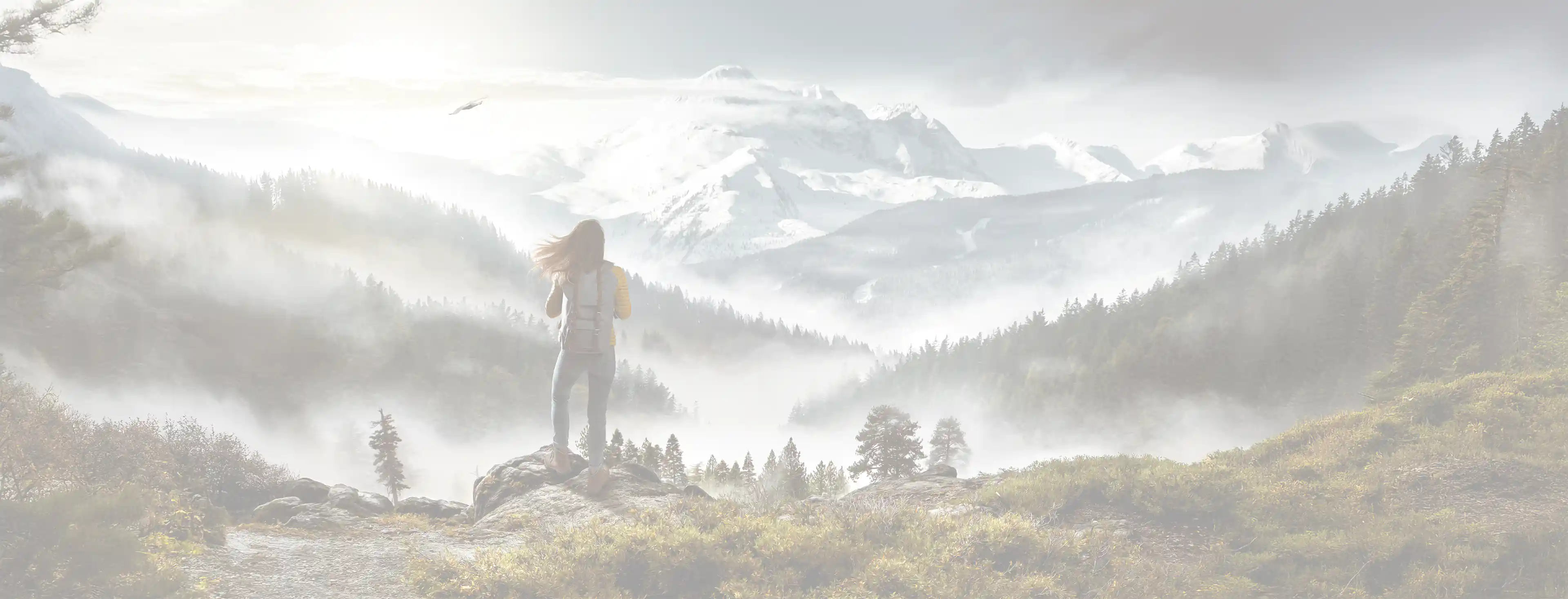 Wanderin mit Rucksack vor einer Berglandschaft