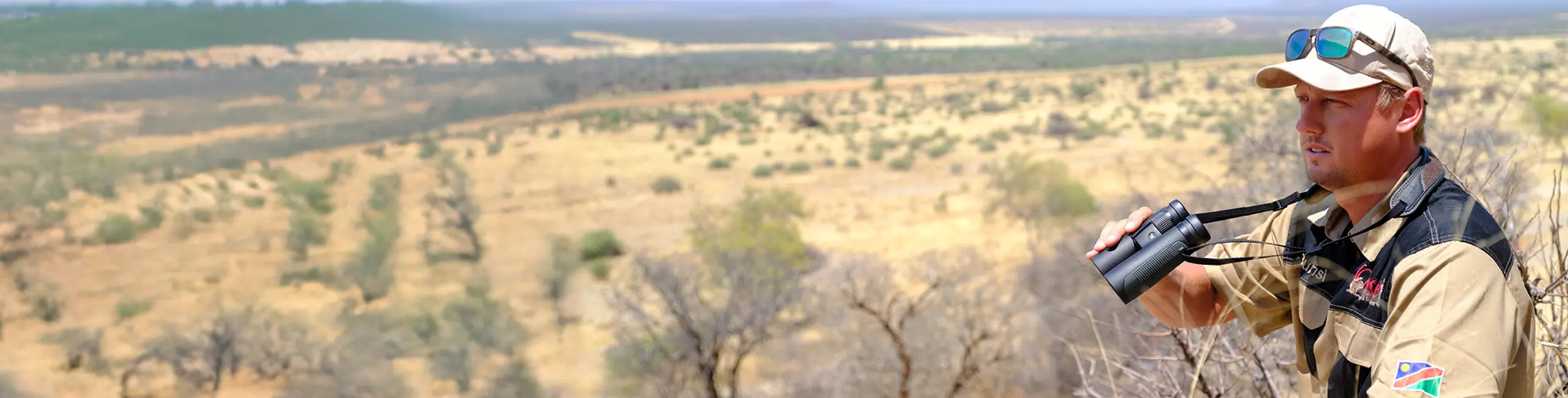 Jagdguide mit DDoptics NXT Fernglas überblickt die Landschaft.